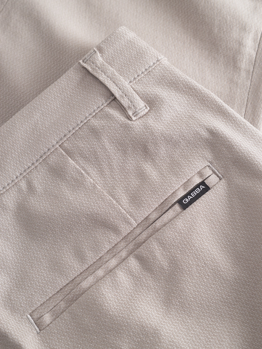 Close-up of grey Pisa K3280 Dale Pants by Gabba with a neatly stitched back pocket, belt loop, and a label above the pocket. The high-stretch fabric has a smooth texture with a subtle pinstripe pattern.