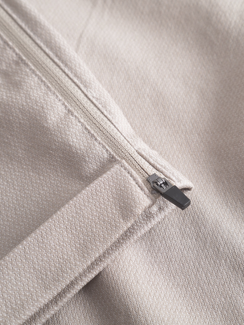 Close-up of Gabbas Pisa K3280 Dale Pants in Grey Paloma, featuring high-stretch fabric and a metal zipper. The subtle texture and detailed stitching are complemented by a partially open zipper revealing layers beneath the smooth surface.