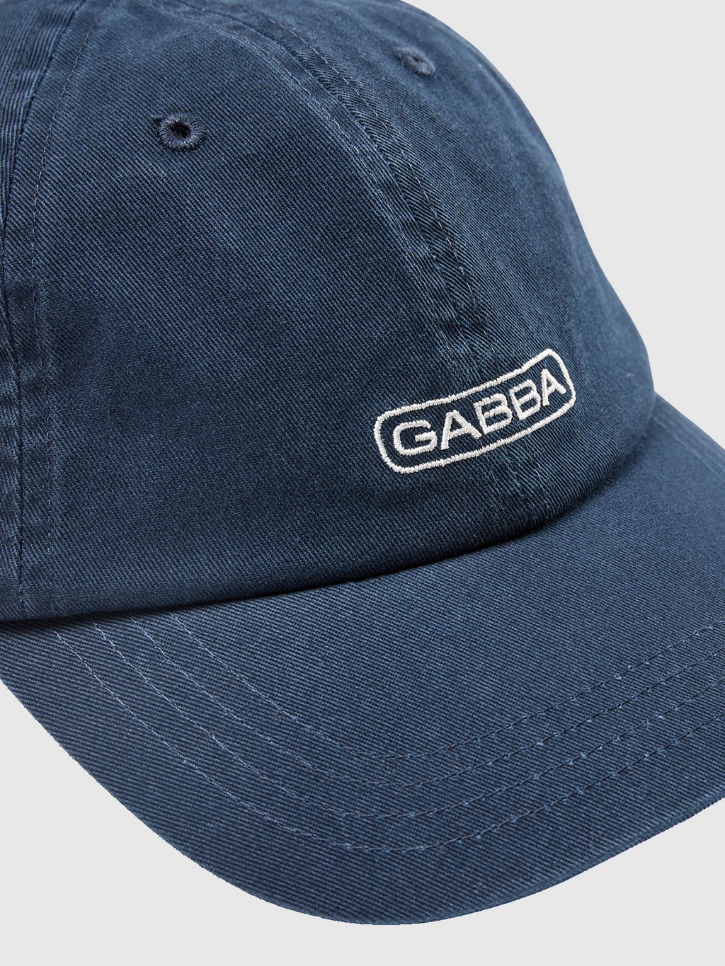 Close-up of the Gabba Cap - Navy Blazer, showcasing GABBA embroidered in white on the front. This cap by Gabba has a classic design with a curved brim, visible stitching details, and a comfortable fit.