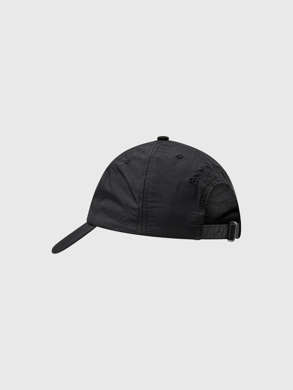 The Gabba Ribstop Cap - Black by Gabba is displayed from the side, showcasing its curved brim, embroidered text, and adjustable strap for a comfortable fit. The background is plain gray.