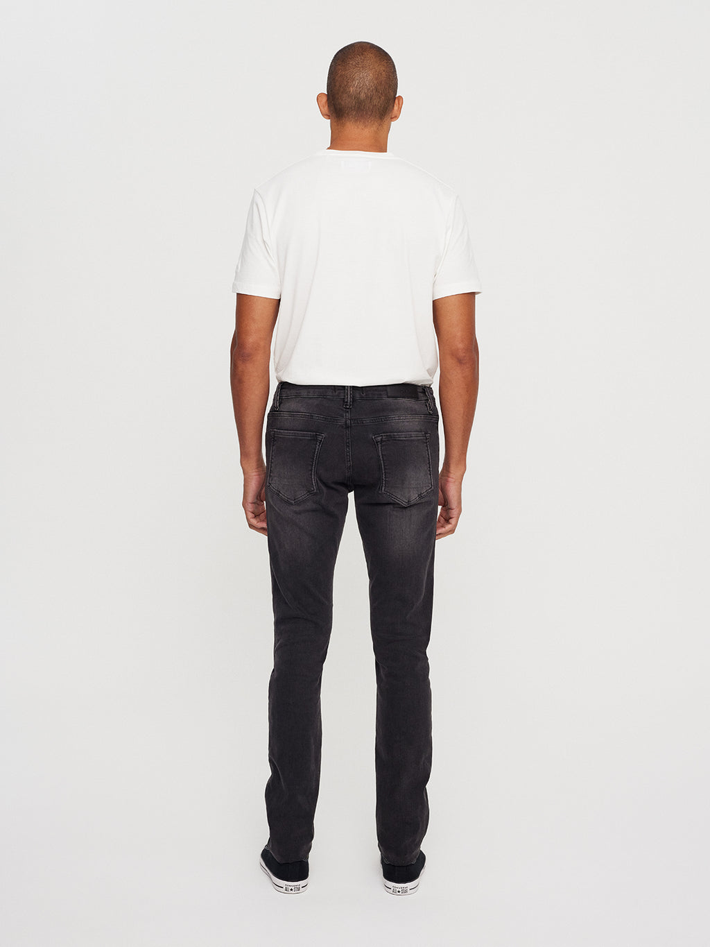 The individual, facing away from the camera, is sporting a white T-shirt paired with Gabbas Jones K3459 grey denim. These slim silhouette jeans, crafted from super-stretch fabric, perfectly complete their look against the plain white background.