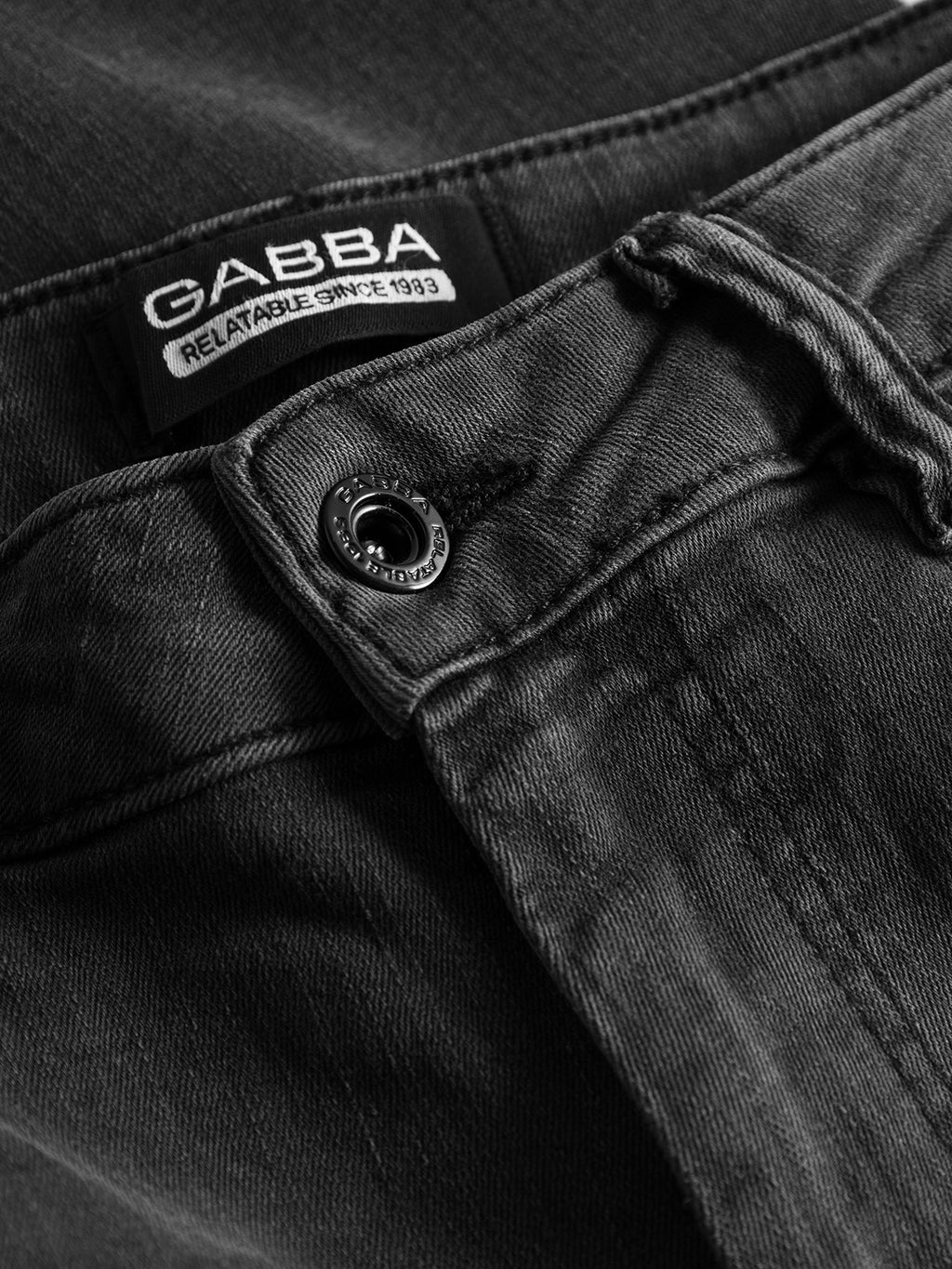Close-up of grey denim jeans with a button and the Gabba label showing the slogan RELATABLE SINCE 1983. The super-stretch fabric and stitching of the Jones K3459 emphasize a perfect fit and slim silhouette, bringing style to life.