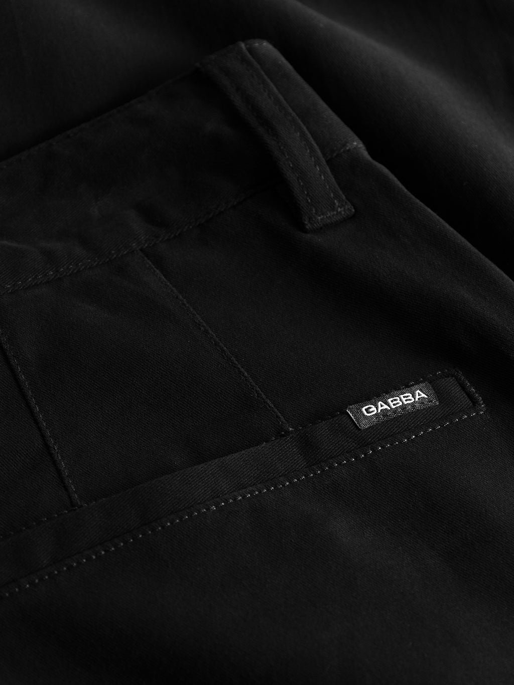 Close-up of the black fabric pocket on Gabbas Venza Chino with a vertical seam and belt loop. A small black label with white Gabba text is sewn at the pockets edge, making it essential for any mens wardrobe seeking regular fit sophistication.