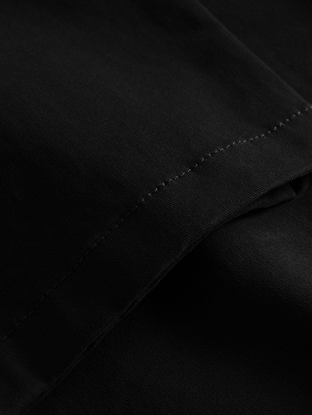 Close-up of Venza Chino - Black by Gabba, showing a seam with neat stitching on smooth black fabric, hinting at a regular fit style.