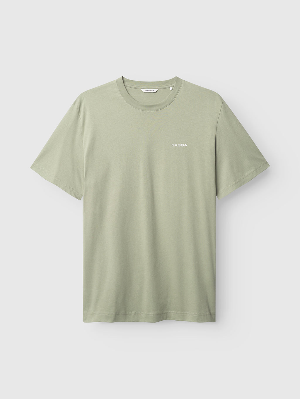 The Dune Logo SS GOTS in light green by Gabba is a GOTS-certified organic cotton t-shirt with a round neckline and short sleeves, featuring a small white logo on the left chest, making it an ideal eco-friendly basic for fashion enthusiasts.