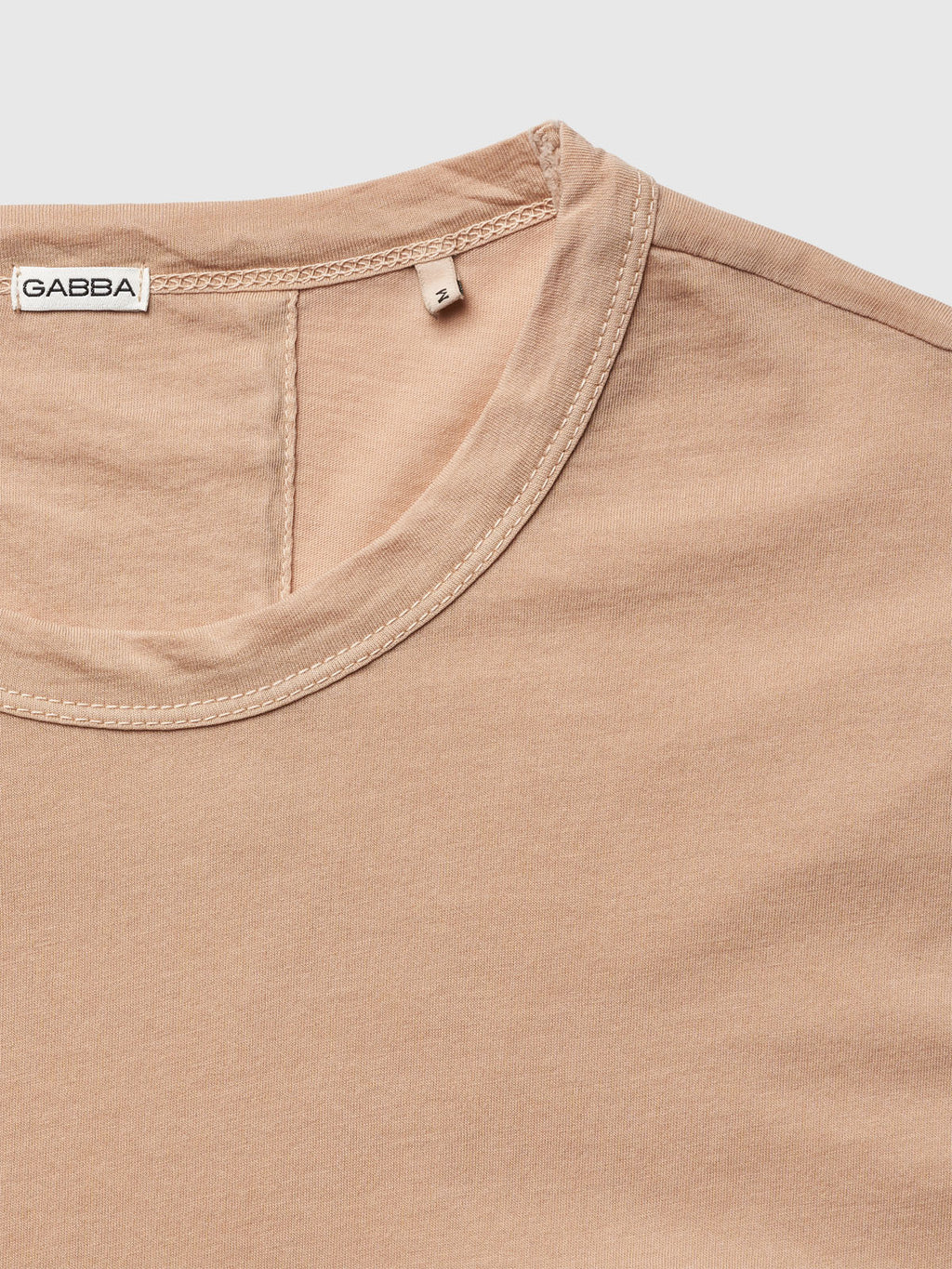 The beige Lagos SS - Safari t-shirt by Gabba boasts a round neckline, visible stitching, and a classic fit for comfort. It has a small label inside the collar with Gabba and size 2. The fabric is smooth and soft.
