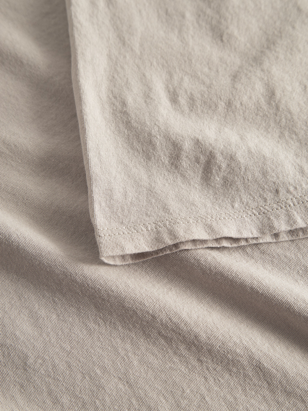 Close-up of Gabbas Lagos SS - Sand, displaying all-day comfort and a classic fit. The beige fabric is smooth with a slight texture, draping naturally with soft shadows and folds that enhance its texture.