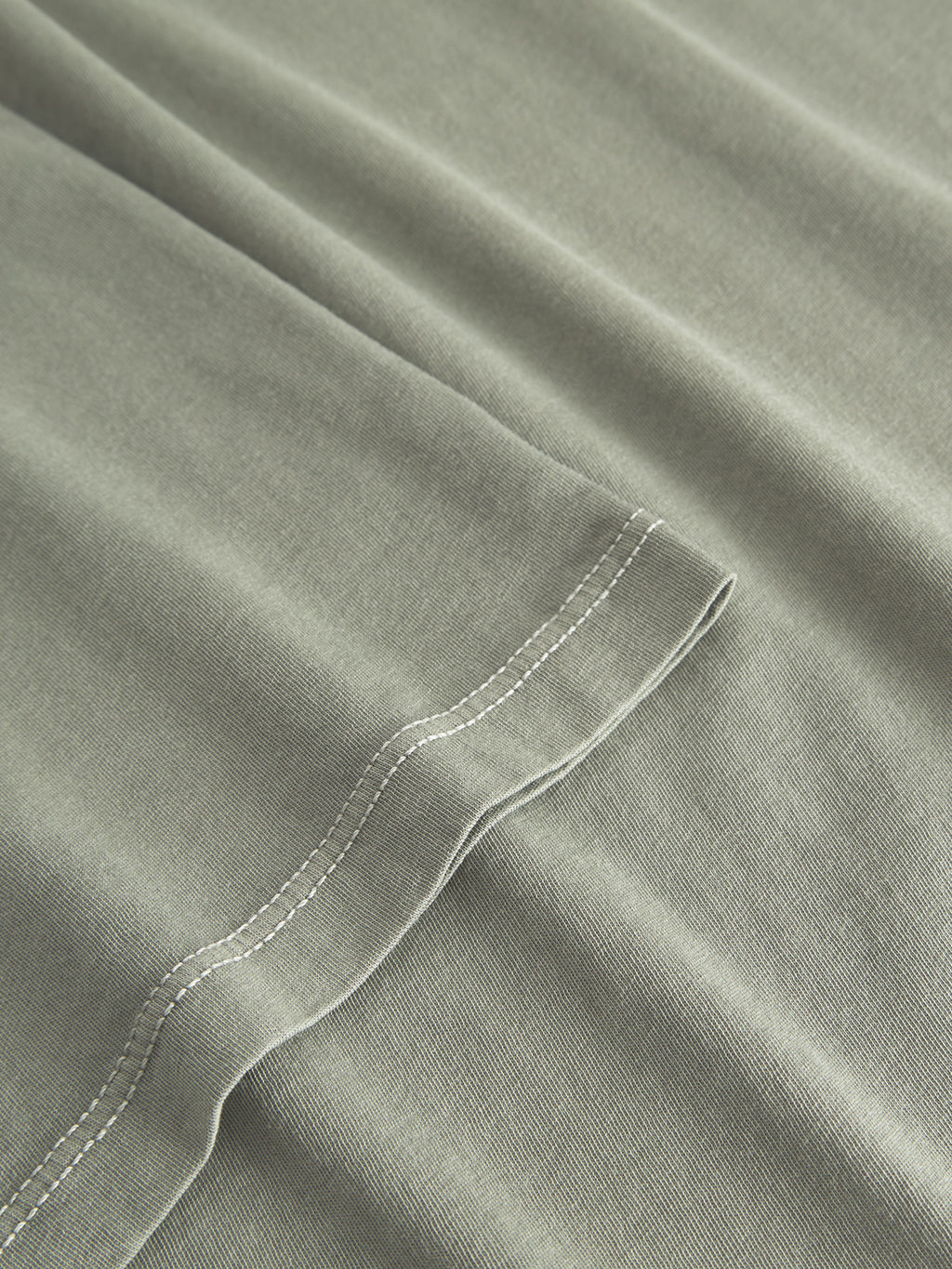 Close-up of the Gabba Lagos SS - Green Sea, showcasing its smooth texture and comfortable round neckline. Visible stitching and neatly sewn hems give it a clean, simple look, reminiscent of a classic fit t-shirt.