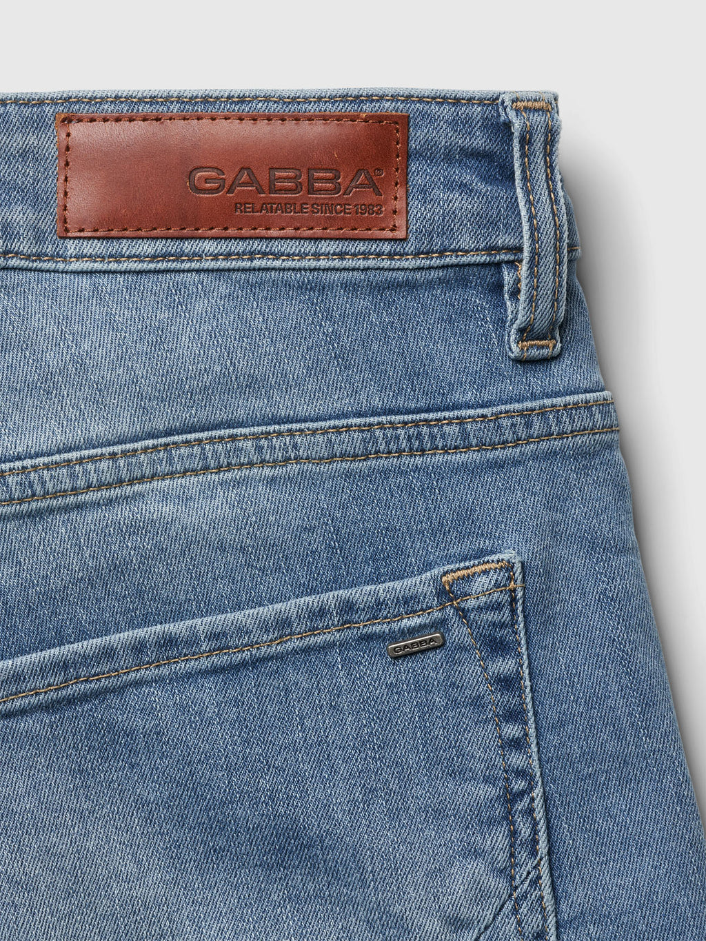 Close-up of the Gabba Markus K4664 Shorts in light blue denim, featuring a leather patch on the waistband with GABBA RELIABLE SINCE 1983 embossed. Crafted for comfort, these shorts showcase visible stitching and a small metal detail near the pocket.