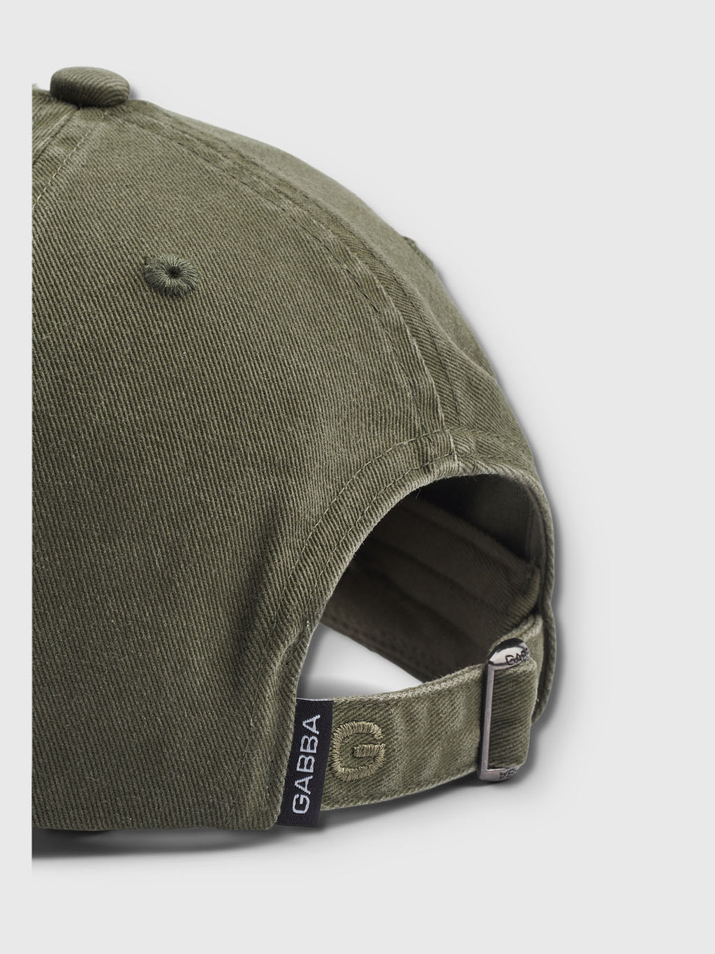 Close-up of Gabbas Dad - Army cap in olive green cotton, featuring an adjustable strap buckle with a small black tag reading GABBA for a comfortable fit.