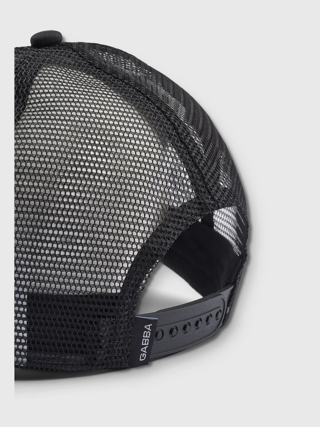A close-up of the Gabba Wolf Cam - Meteorite, a black mesh baseball cap with an adjustable snap strap. The breathable mesh features a small Gabba logo tag, set against a white background that highlights its details.