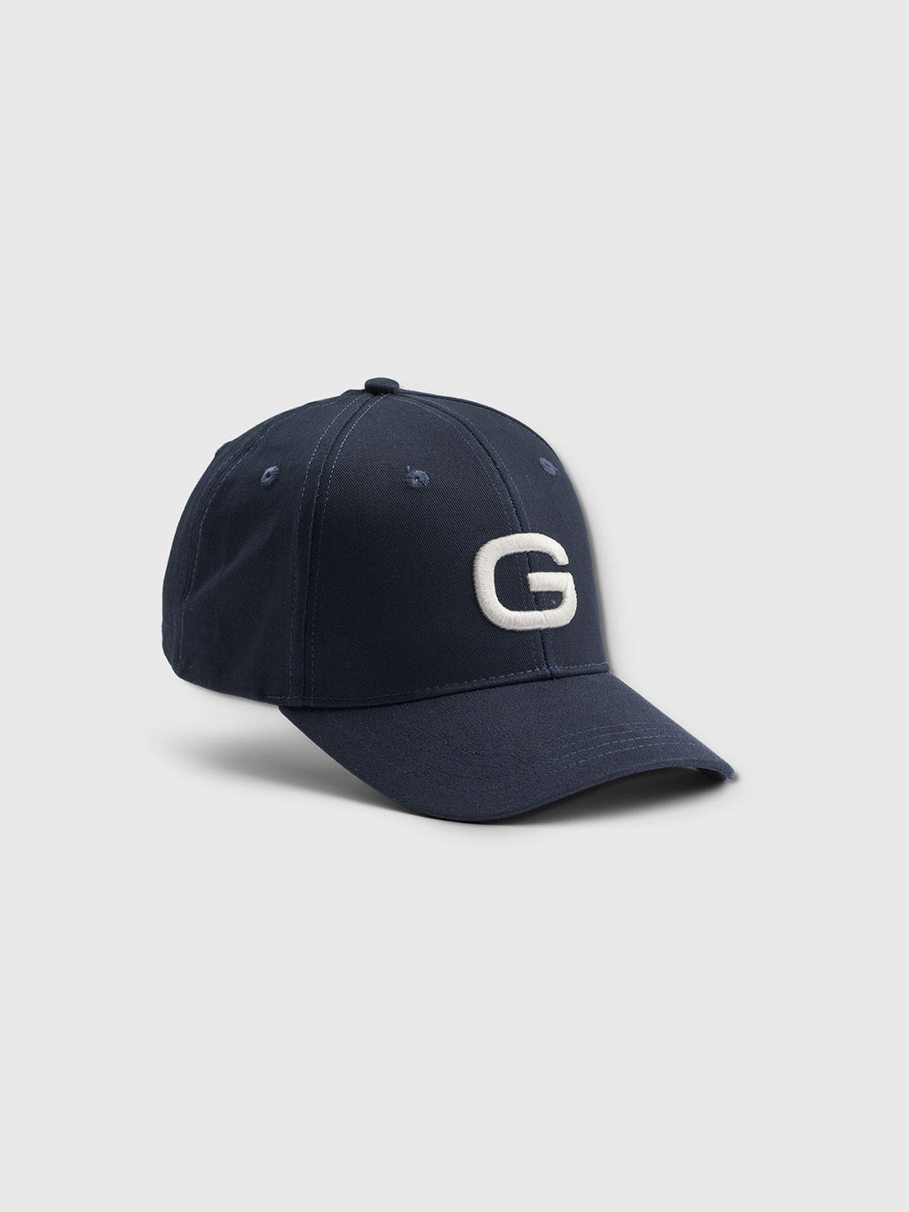 The Gabba Base - Navy cap features a raised white G on the front, classic fit, curved brim, and visible stitching, blending timeless style with modern design.