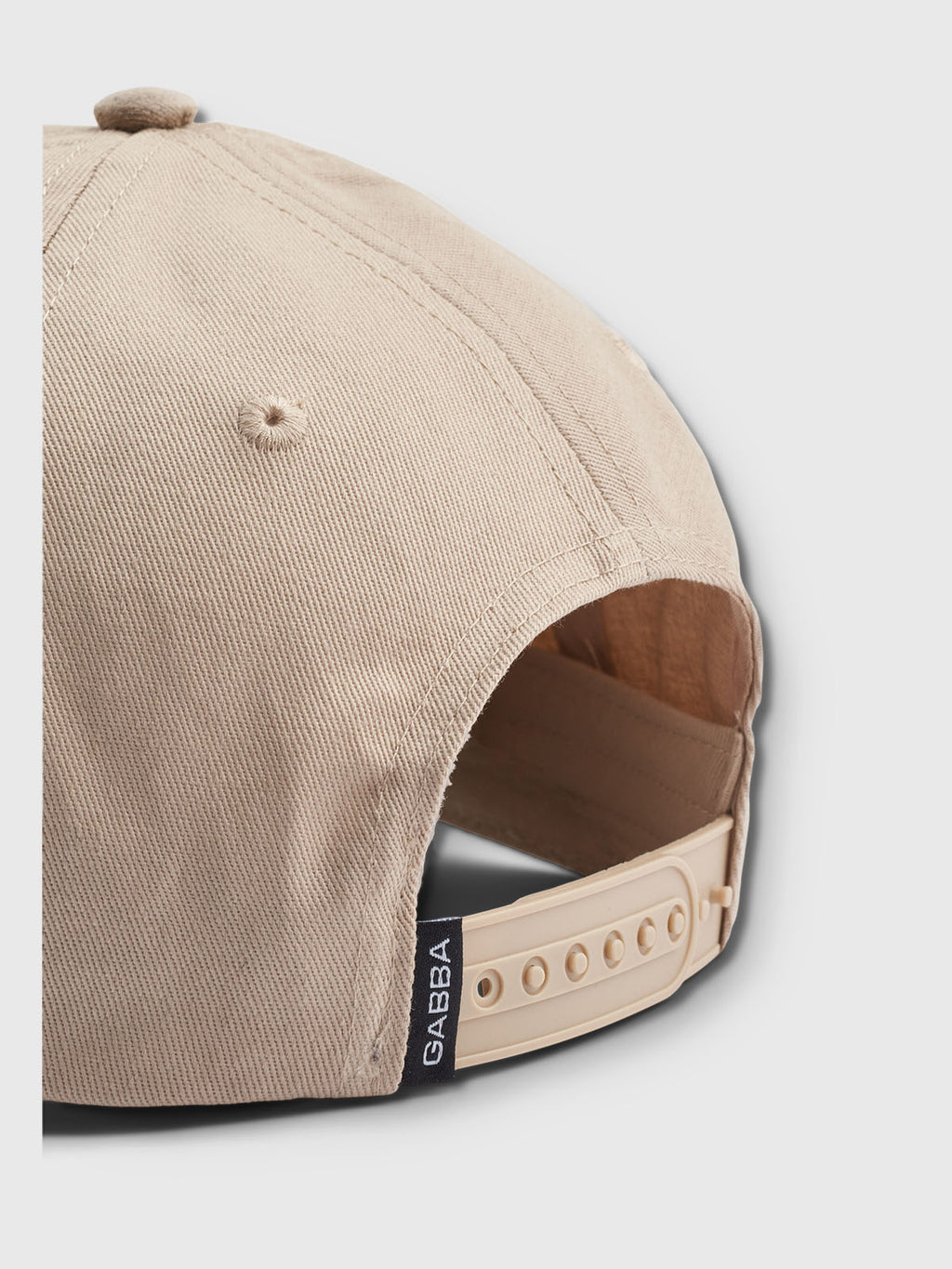 The Sand Base baseball cap by Gabba features a modern design with an adjustable snapback. Viewed from the back, it has a small black tag with Gabba on it, adding style to its classic fit.