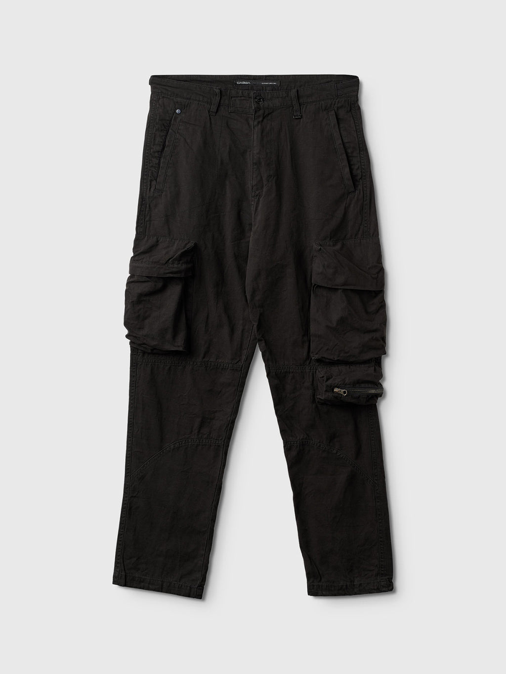 The Rodi Cargo Pant by Gabba features multiple pockets, large side flap pockets, and a relaxed fit. Made from durable cotton with a waist button closure, these black cargo pants offer comfort and style for casual or outdoor wear.