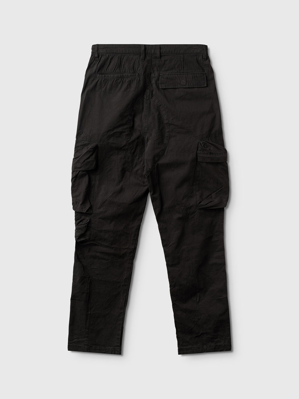 The Gabba Rodi Cargo Pant - Black, crafted from durable cotton for comfort and texture, is showcased on a light gray background. It features two large side pockets with flaps and button closures, plus back pockets.
