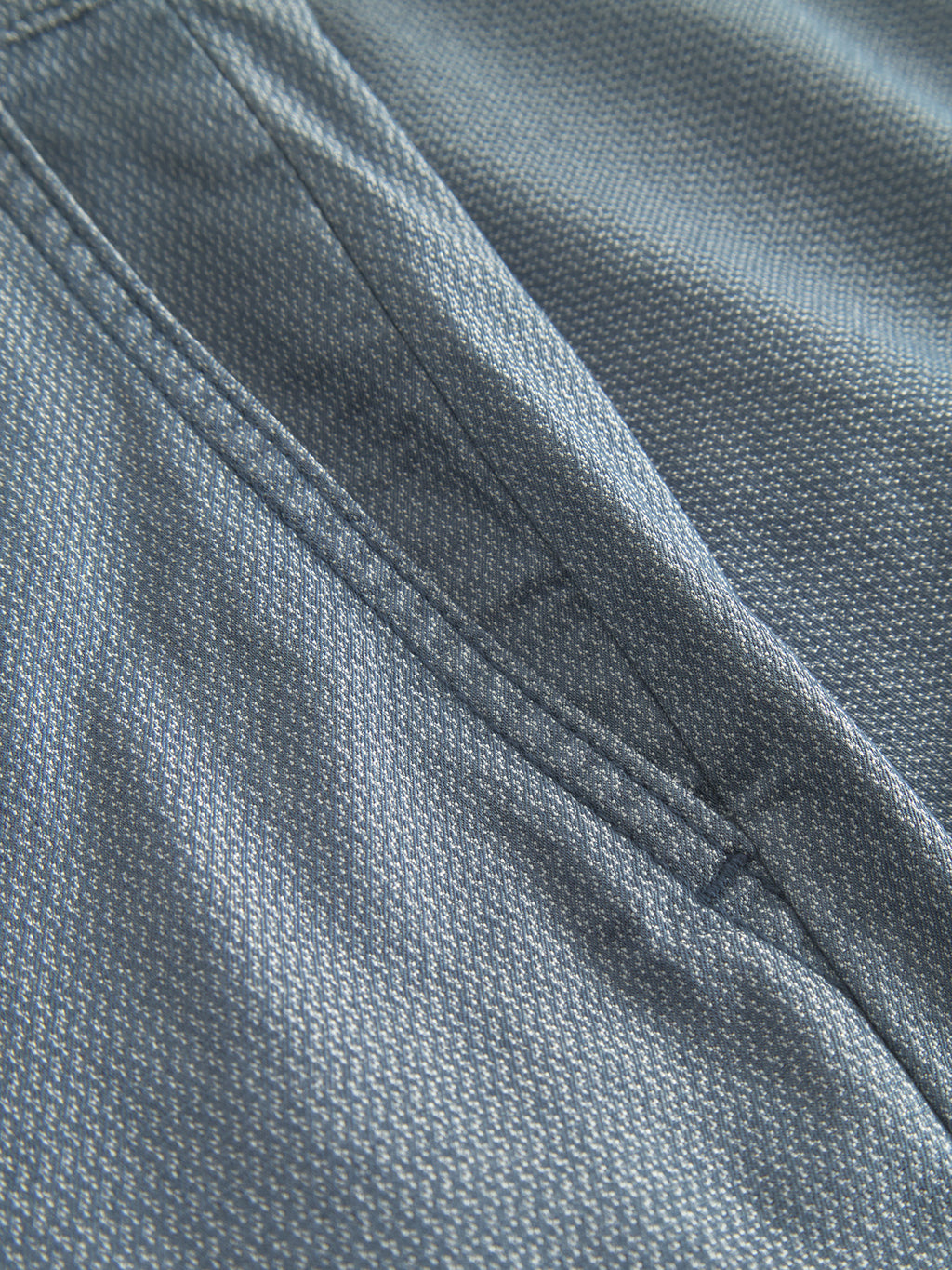 Close-up of the Gabba Jet K3280 Dale Shorts in muted blue, featuring a subtle pattern and timeless diagonal stitching. The textured fabric promises a comfortable fit, perfect for clothing like shorts or a jacket.