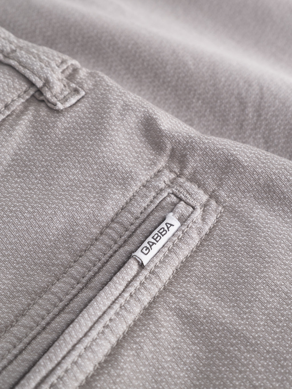 Close-up of a Jet K3280 Dale Shorts pocket in Grey Paloma textured fabric, featuring a small Gabba tag near the seam, highlighting the garments detailed design and timeless appeal for a comfortable, stylish fit.