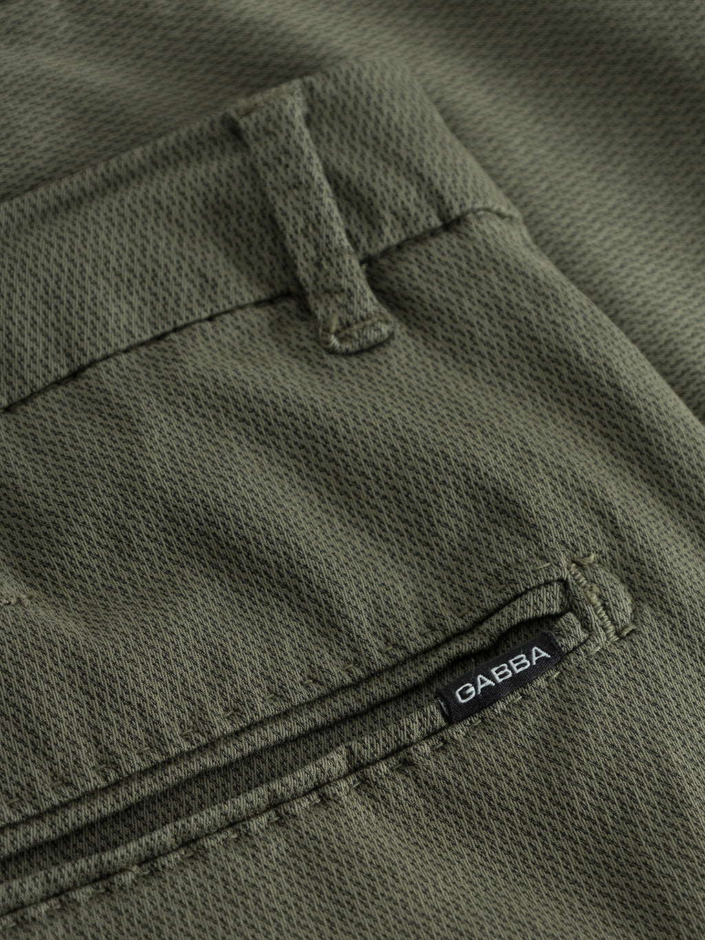 Close-up of Jet K3280 Dale Shorts in deep lichen green by Gabba, featuring modern textured fabric and a stitched pocket with a black label showcasing the brand name in white lettering, offering effortless style.