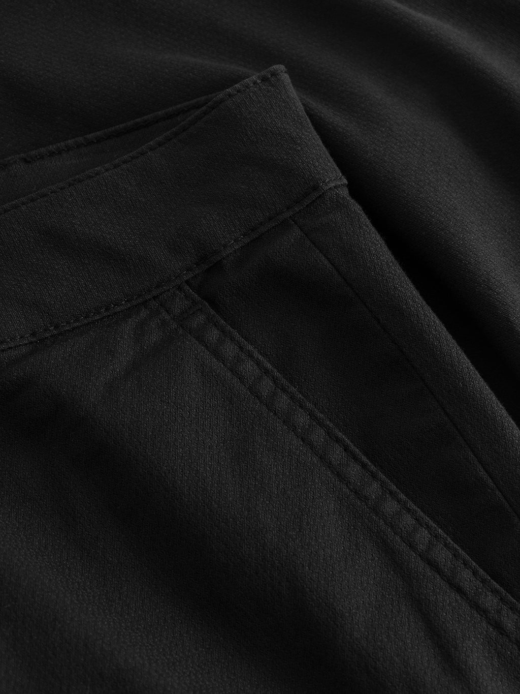 Close-up of the Jet K3280 Dale Shorts in Black by Gabba, showcasing a seam and pocket. The smooth, slightly textured black fabric is designed for all-day comfort with a subtle sheen that highlights its modern design and clean stitching.