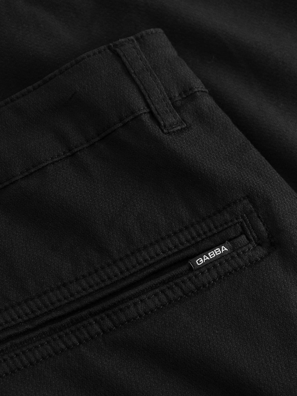 A close-up of the Jet K3280 Dale Shorts in black showcases detailed stitching and a zippered pocket, offering a modern design. The smooth fabric promises all-day comfort and features a small Gabba brand tag in white letters near the zipper.