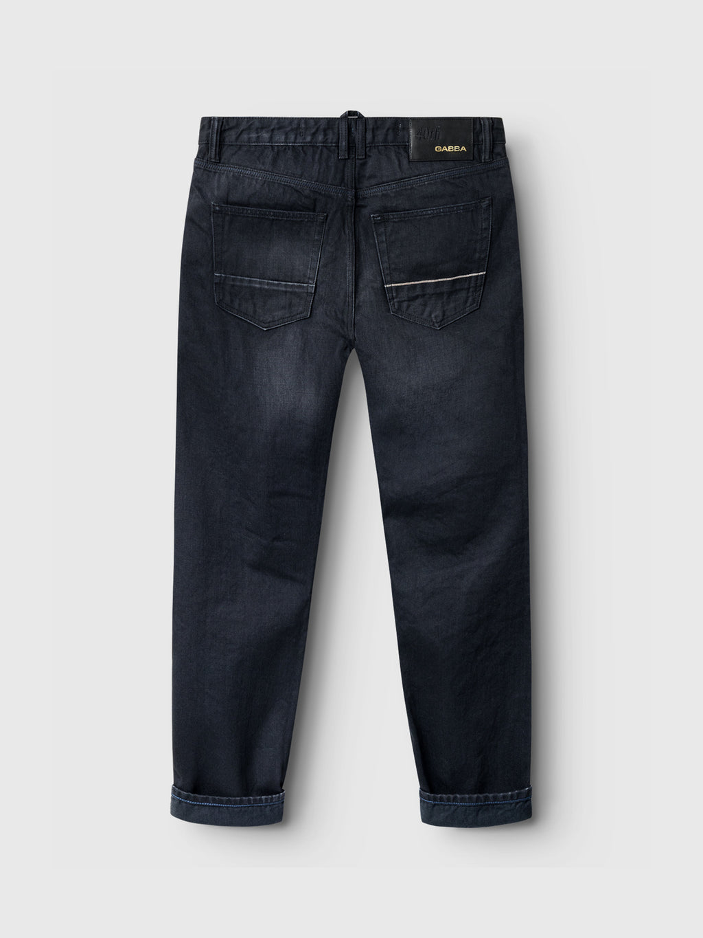 Back view of Gabbas Carl Selvedge 40th Anniversary blue-black denim jeans, showcasing a unique marble look. They feature two back pockets, a folded hem, and a black label with gold text on the waistband. The slightly faded fabric gives them a worn-in appearance.