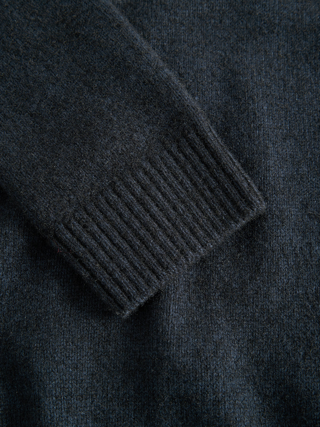 Close-up of a navy Luca Ls sweater by Gabba, highlighting the ribbed cuff detail in plaited knitting. The texture of the soft, mixed regular wool is beautifully visible.