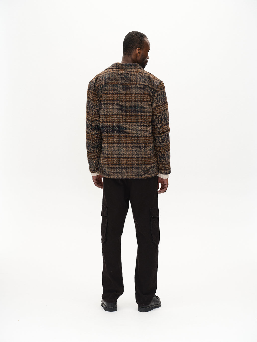 A man with his back to the camera wears Gabbas Oscar J Check - Multi Check wool blend jacket paired with black cargo pants, set against a plain white background.