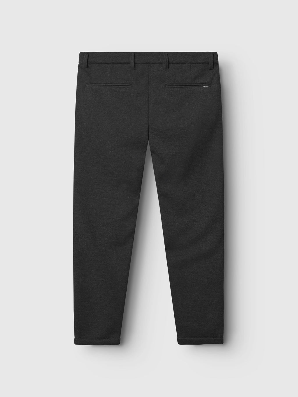 The Pisa GKnit - Dk. Grey by Gabba are straight-leg black dress pants crafted from innovative structured fabric, featuring two back pockets with subtle button closures, displayed against a plain light gray background.
