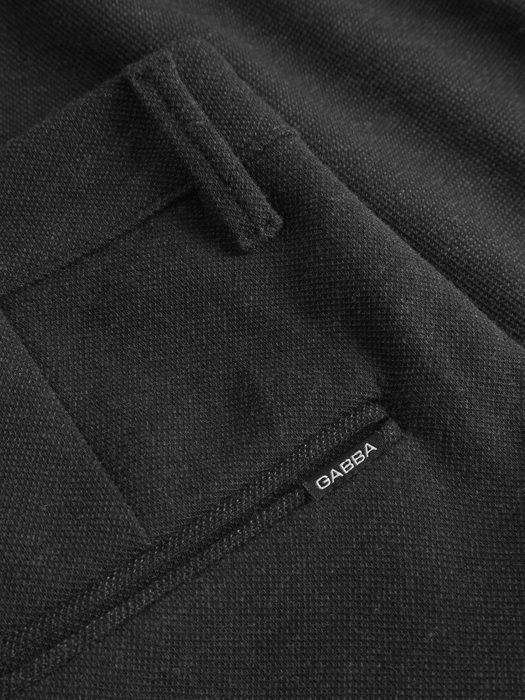 Close-up of the Pisa GKnit - Dk. Grey pants highlights their innovative structure fabric. A small Gabba label is stitched near the neatly sewn pocket edge.