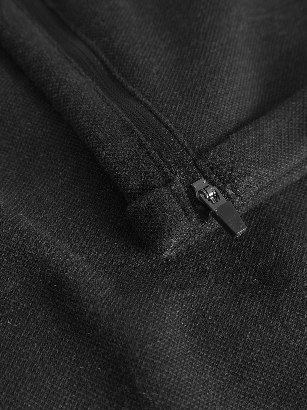 Close-up of the Pisa GKnit by Gabba, highlighting a black zippered pocket on a dark grey textured fabric that is soft and slightly fuzzy.