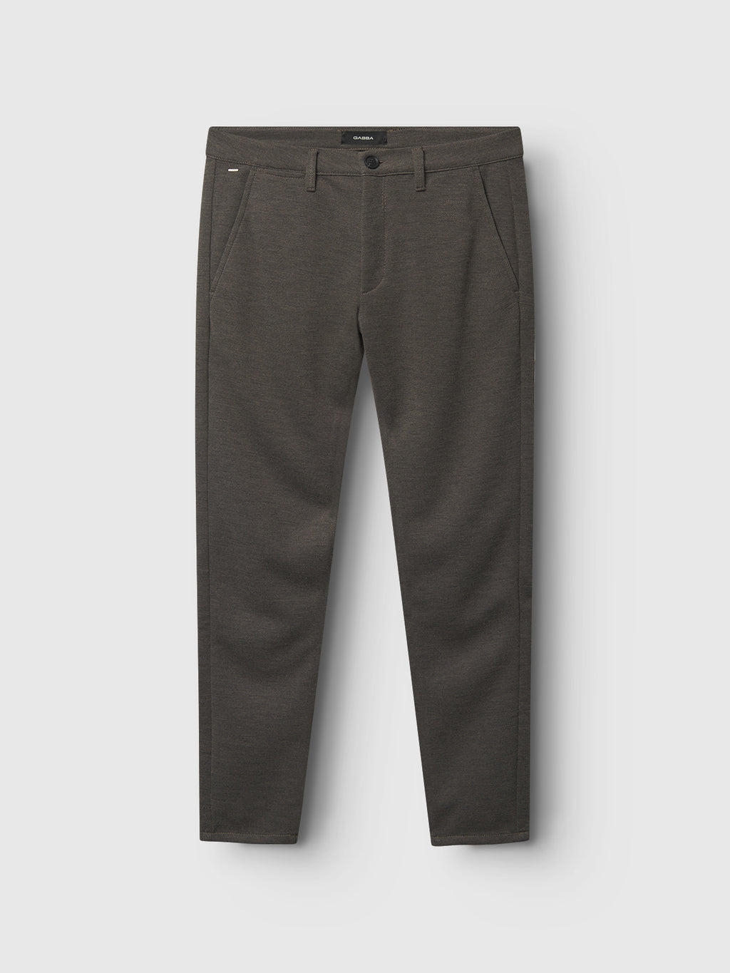 The Gabba Paul GKnit pants in sand are neatly placed against a light gray backdrop. These stylish slim-fit trousers feature a button and zip closure, with side and back pockets crafted from structured fabric.