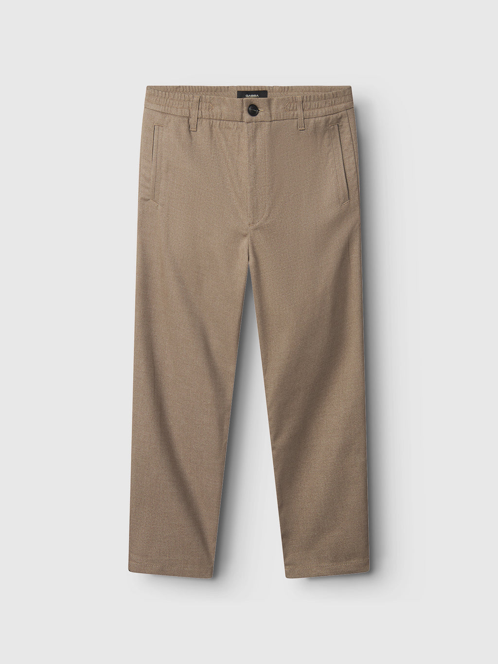 Flat lay of Gabba’s Monza Shafi - Brown relaxed straight fit dress pants in light brown brushed cotton, featuring side pockets, belt loops, and a black button closure at the waistband, shown on a light gray background.
