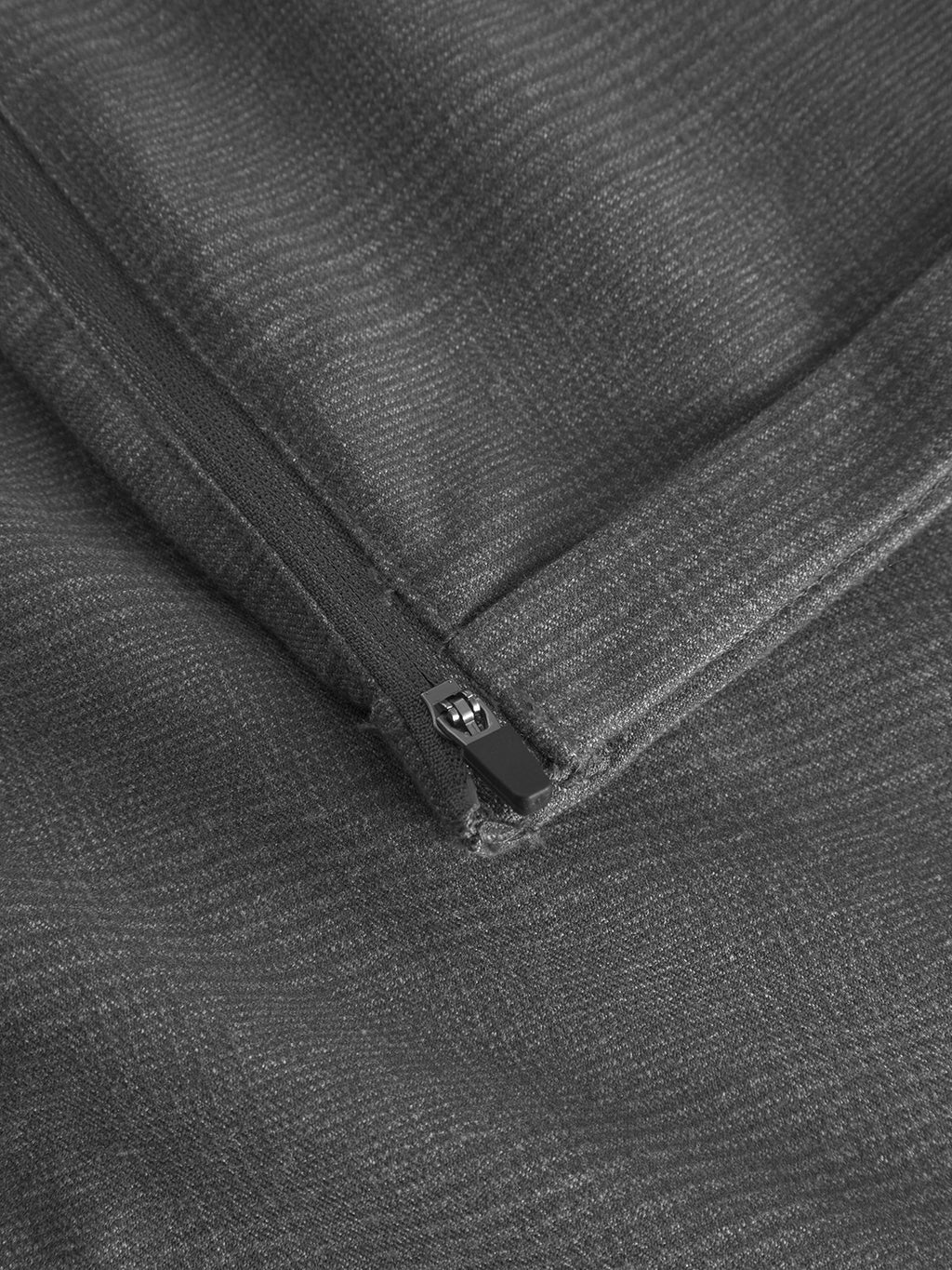 The close-up image shows the Gabba Pisa Field - Grey fabric with a textured look. Its high-stretch cotton blend features a subtle herringbone pattern and a partially opened zipper running diagonally, capturing metro-style elegance.