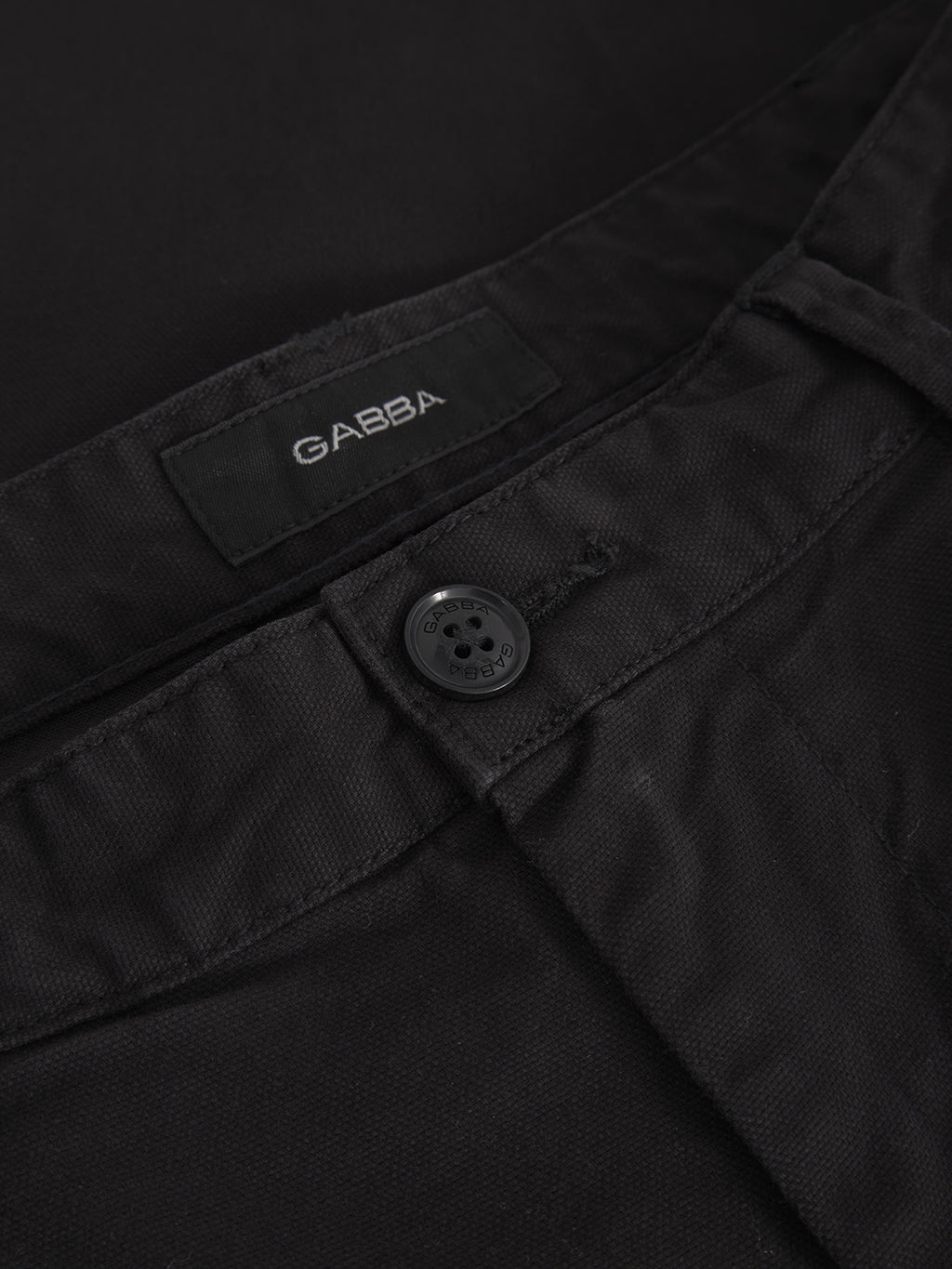 A close-up of the Gabba Verona Ent Poc - Meteorite pants highlights the button and waistband with an emphasis on the brand label. The fabric, akin to smooth jeans, is slightly textured with spacious side pockets for convenience.