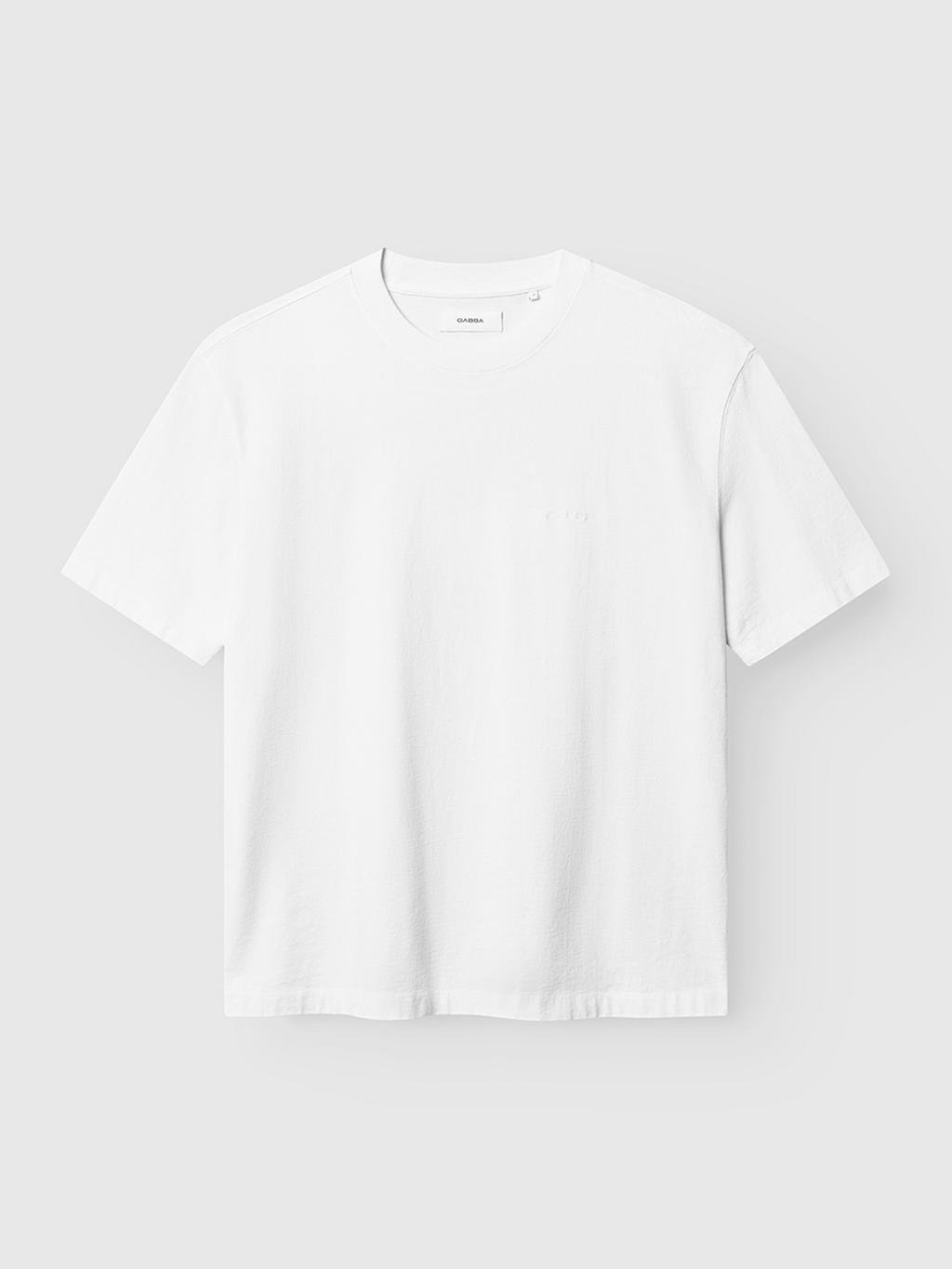 The Gabba Nigel Wix Boxy Hour SS - White is a vintage-inspired boxy-fit tee with short sleeves and a crew neckline, crafted from soft garment-dyed cotton, shown against a light gray background.