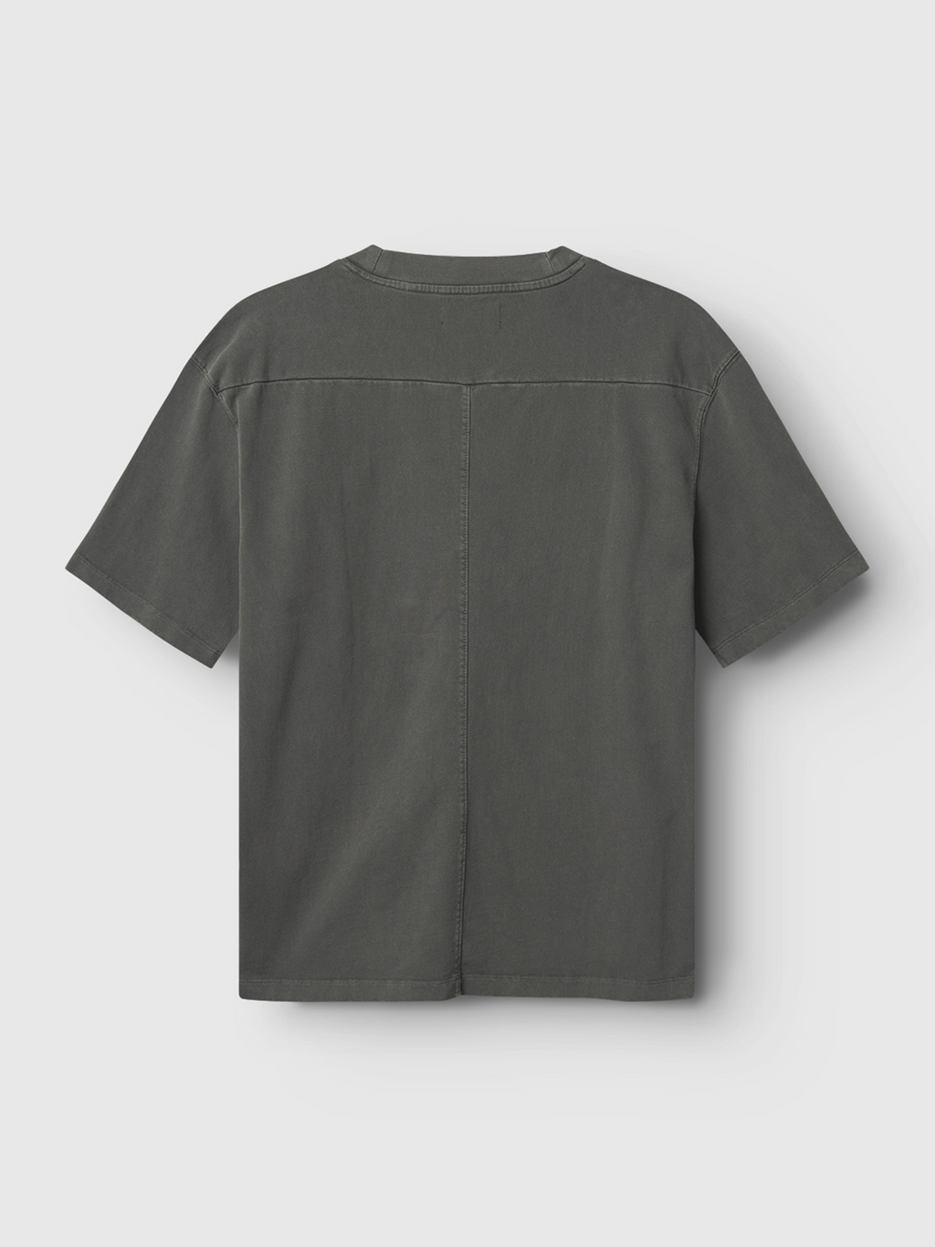 The Gabba Nigel Wix Boxy Hour SS tee in dark grey is shown from the back, displaying visible vertical and horizontal seam details. This short-sleeve, boxy-fit shirt is laid flat on a light grey background.