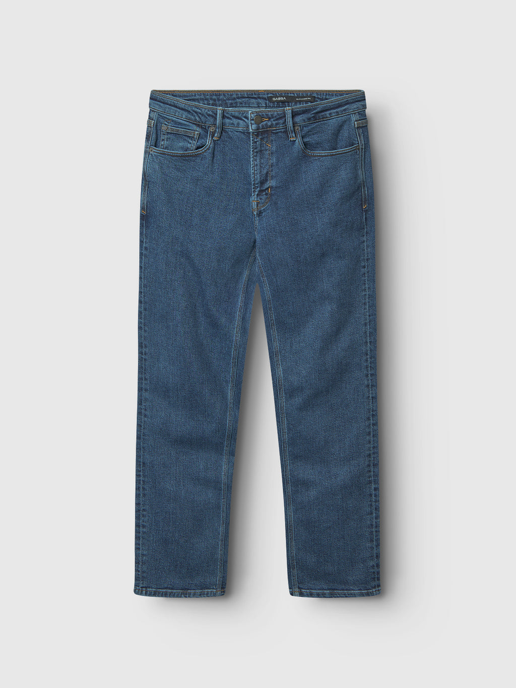 The Max Cros - Mid Blue Denim from Gabba is displayed against a light gray background, showcasing understated elegance with its classic five-pocket design and visible stitching on the seams, pockets, and waistband—a refined statement where elegance meets edge.