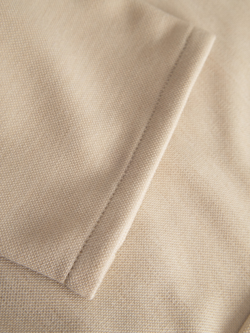 Close-up of the Venza GKnit - Sand Plaza by Gabba, featuring a beige textured fabric with a neatly sewn pocket and flap. The grid-like pattern reminiscent of classic straight-fitted pants offers an elegant and structured look.