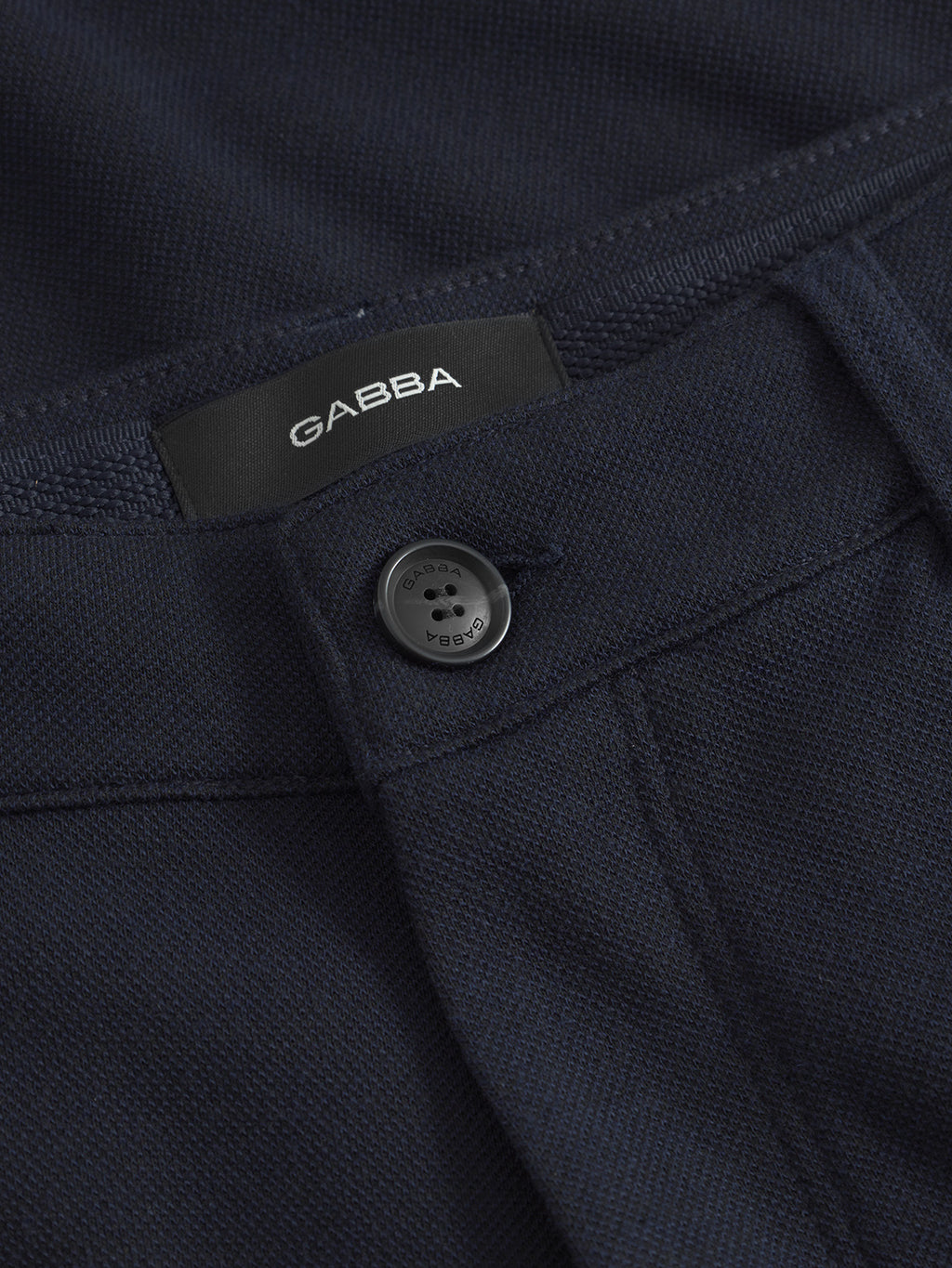 Close-up of the Venza GKnit - Navy by Gabba, featuring an innovative fabric with a sleek black button engraved with Gabba and a matching label. The textured weave blends timeless design, creating a classic piece.