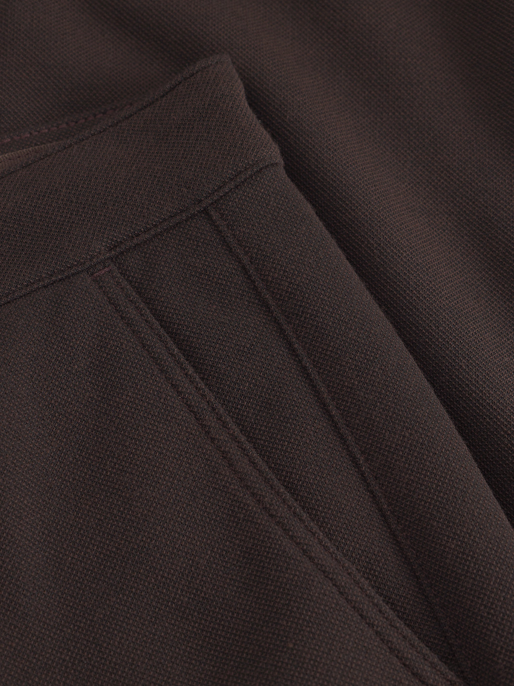 Close-up of Venza GKnit - Brown textured fabric by Gabba, featuring visible seam lines and precise stitching. The soft, structured weave hints at a straight-fitted pant crafted with innovative knitting techniques.