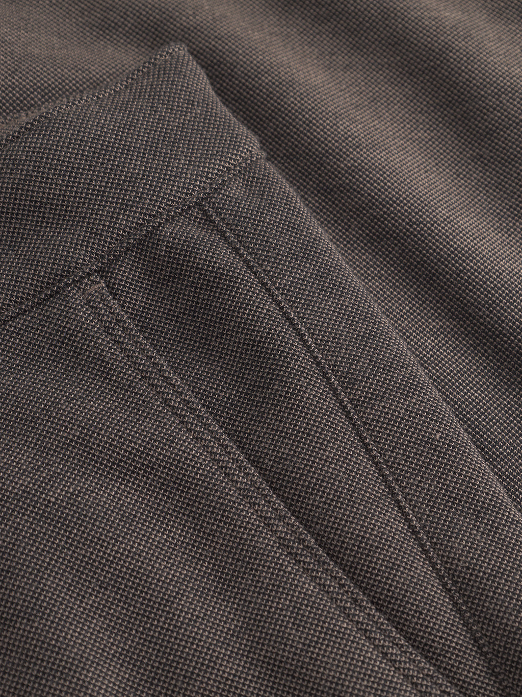 Close-up of classic, textured sand-colored fabric with visible stitching, showcasing a pocket and seam detail. The innovative structure of Gabbas Venza GKnit boasts a coarse weave, highlighting the quality and craftsmanship of the straight-fitted pant.