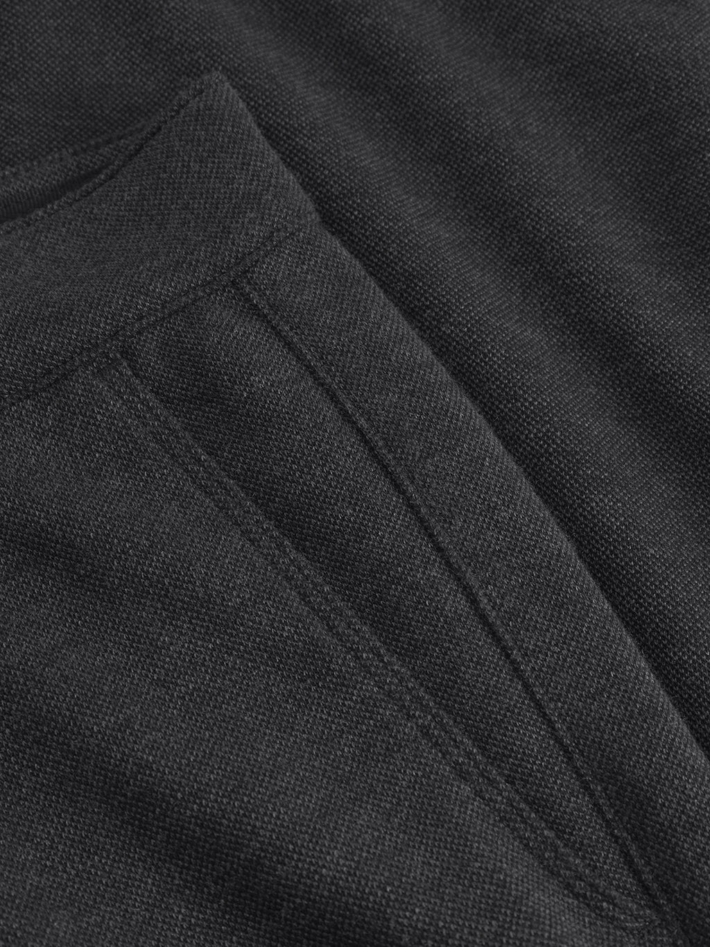 Close-up of Gabbas Venza GKnit in dark gray reveals a textured knit with a slightly rough appearance. Its innovative structure enhances its classic look, featuring a prominent diagonal seam that adds depth and character, reminiscent of straight-fitted pant design.