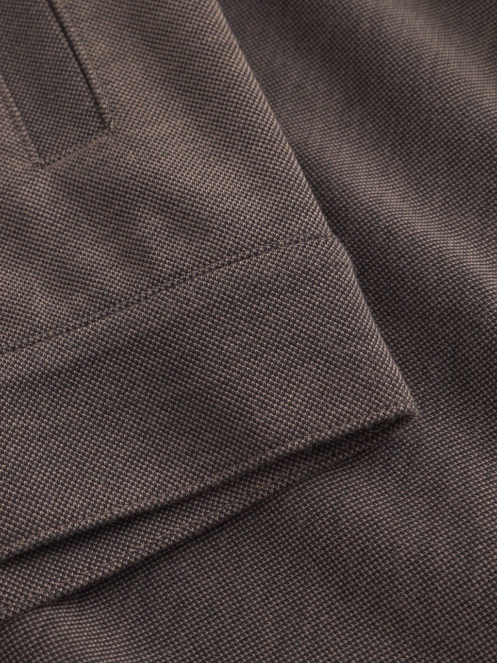 A close-up of Toto Gknit - Sand by Gabba reveals a folded brown viscose mix fabric with a subtle checkered pattern, showcasing a textured appearance perfect for highlighting the intricate weave and craftsmanship in an everyday look.