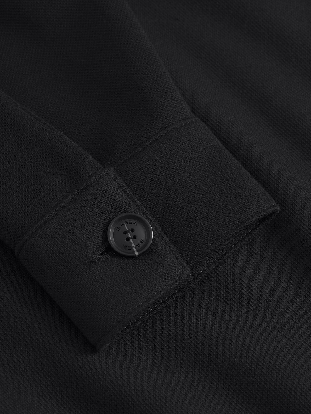 Close-up of Toto Gknit - Meteorite by Gabba, featuring a black fabric sleeve with a glossy black four-hole button on the cuff. The thick, textured material offers durability and comfort, suggesting a blend with soft viscose for everyday wear.
