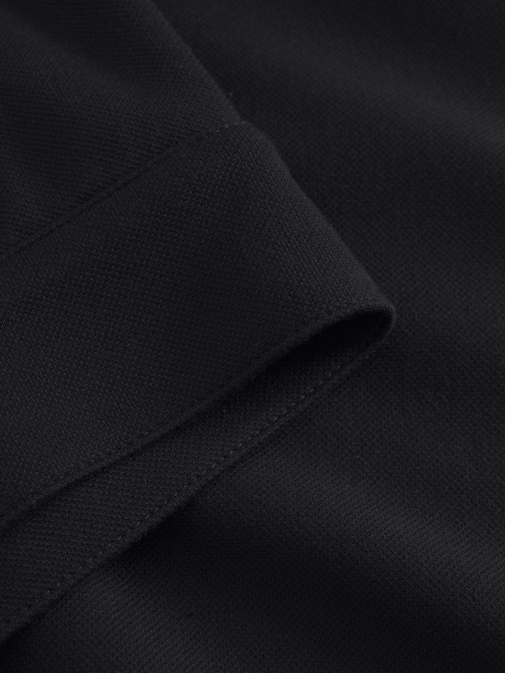 Close-up of Gabbas Toto Gknit - Meteorite, showcasing finely crafted black viscose with a neatly sewn folded seam. The soft, smooth fabric has a slightly ribbed texture, embodying everyday quality and exceptional craftsmanship.