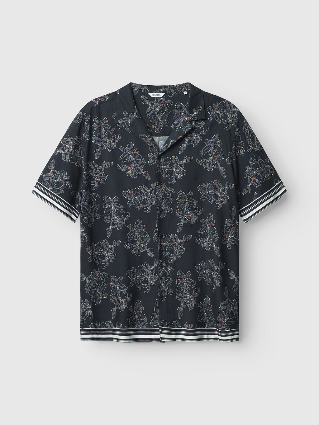 The Gabba Sven Reg Resort Lofi SS - Flower Mix is a black short-sleeve shirt featuring a white tropical floral pattern and striped cuffs. With its relaxed fit and button-down front, it exudes a vacation-ready vibe against a plain light background.