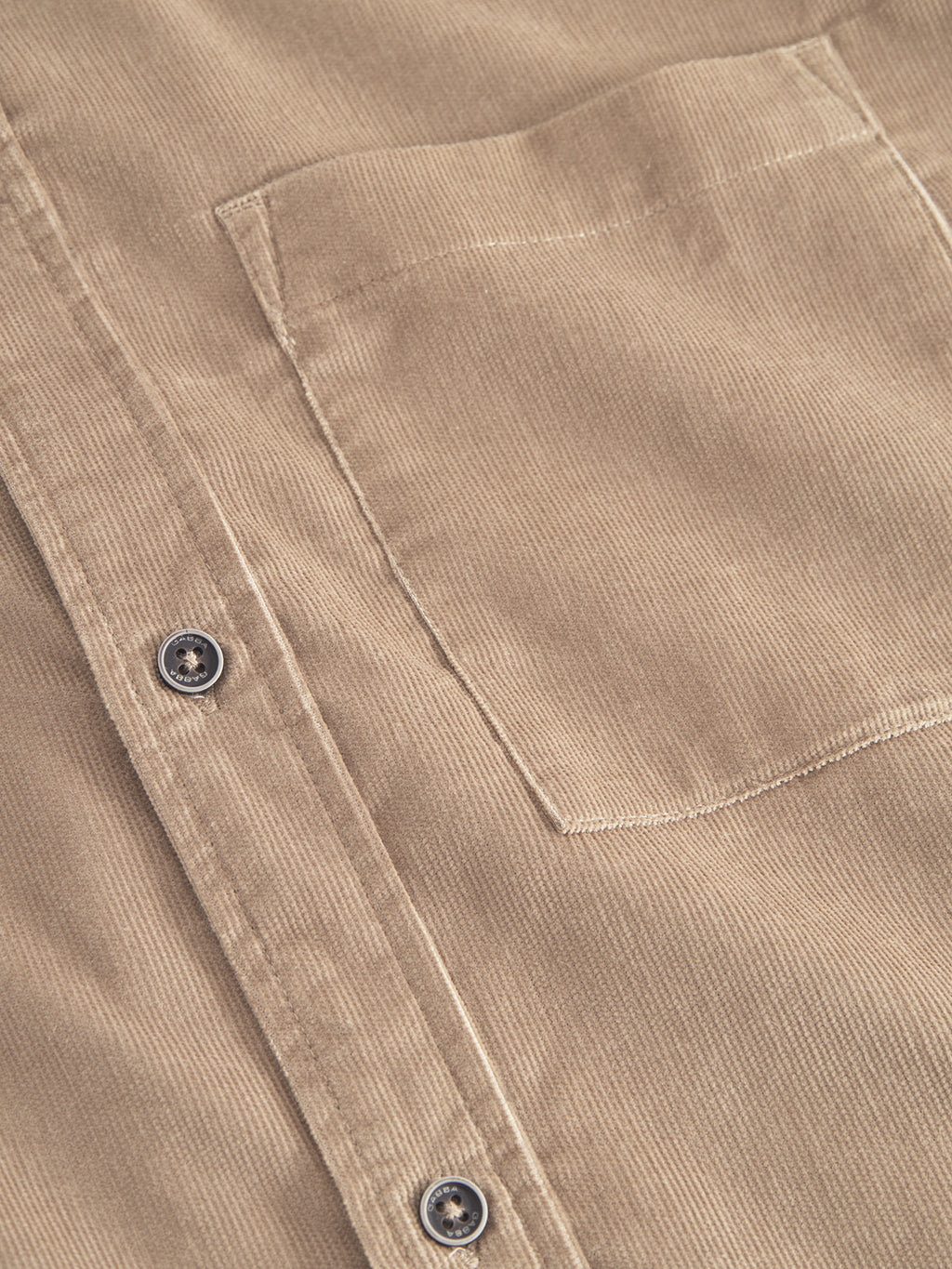 Close-up of Gabbas Sven Reg Cord SS shirt in sand greige, showcasing its beige corduroy texture with a buttoned placket displaying two visible buttons and a subtly stitched chest pocket, made from 100% cotton.