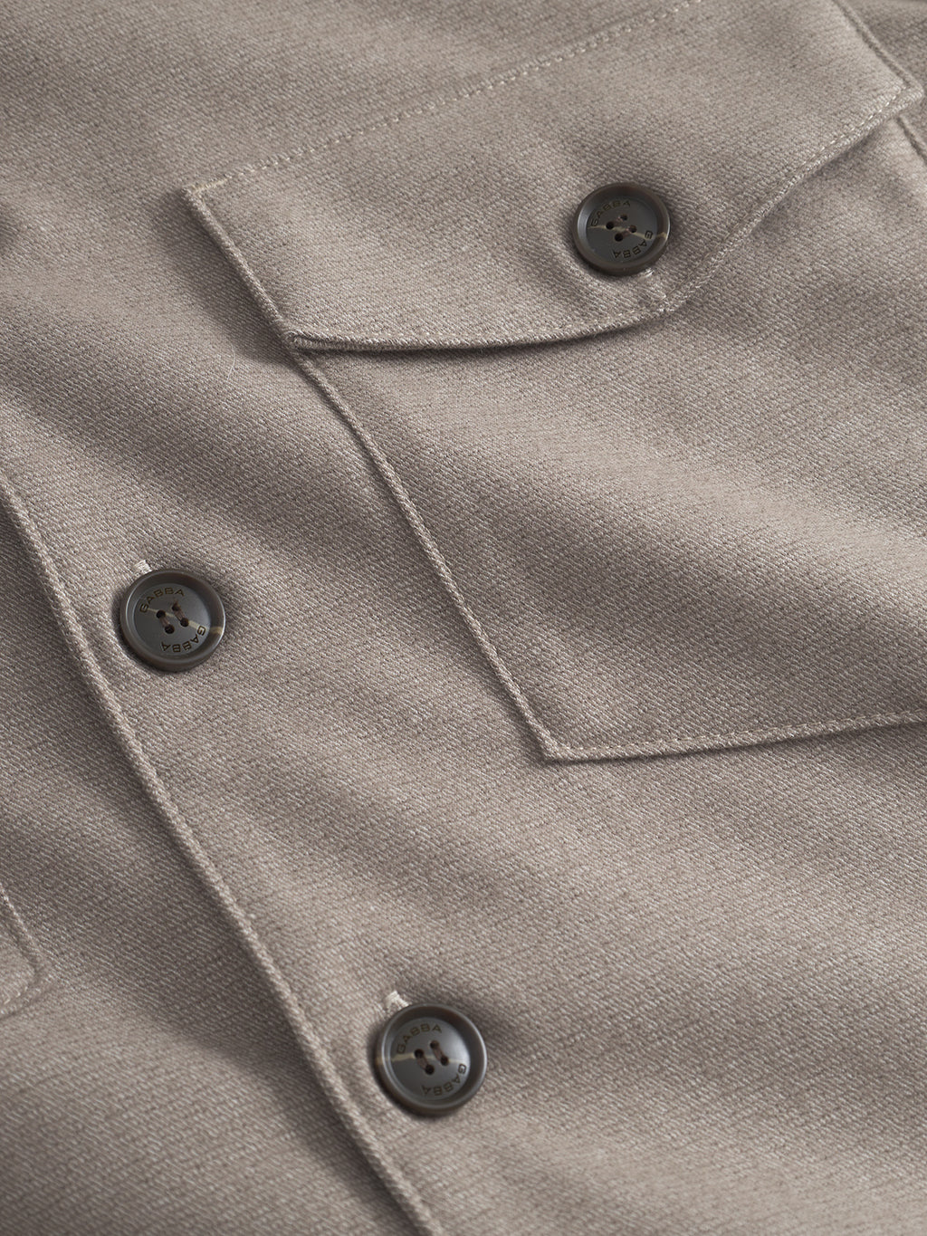 Close-up of the Clipper Shafi - Brown shirt by Gabba, highlighting the beige wool-like fabric with elegant stitching. Features include a front pocket with a flap and three dark buttons, enhancing the intricate design details.