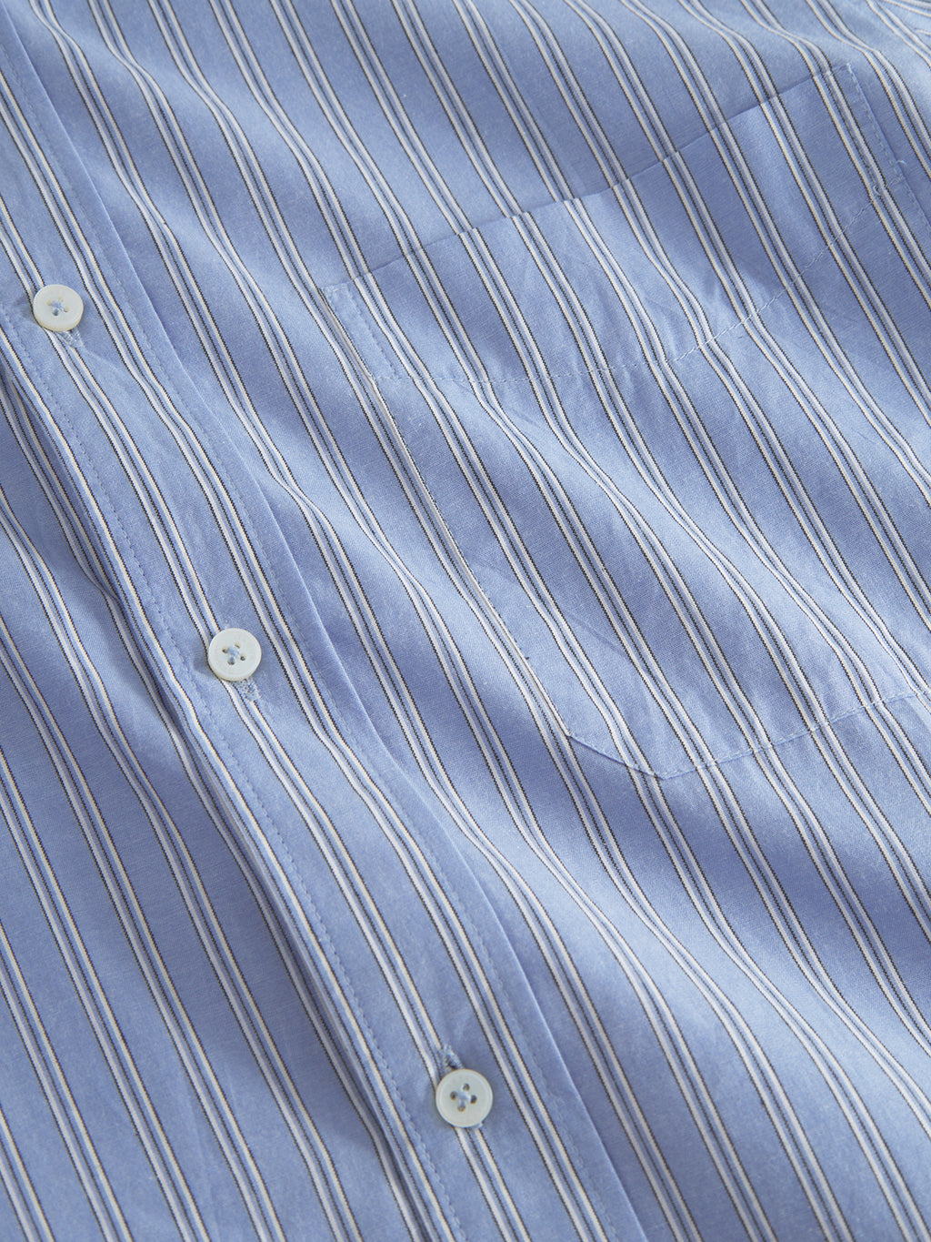 The Sven Reg. Form LS by Gabba is a premium 100% cotton shirt featuring thin white vertical stripes and white buttons on smooth, slightly textured blue fabric, offering a modern dress shirt style.