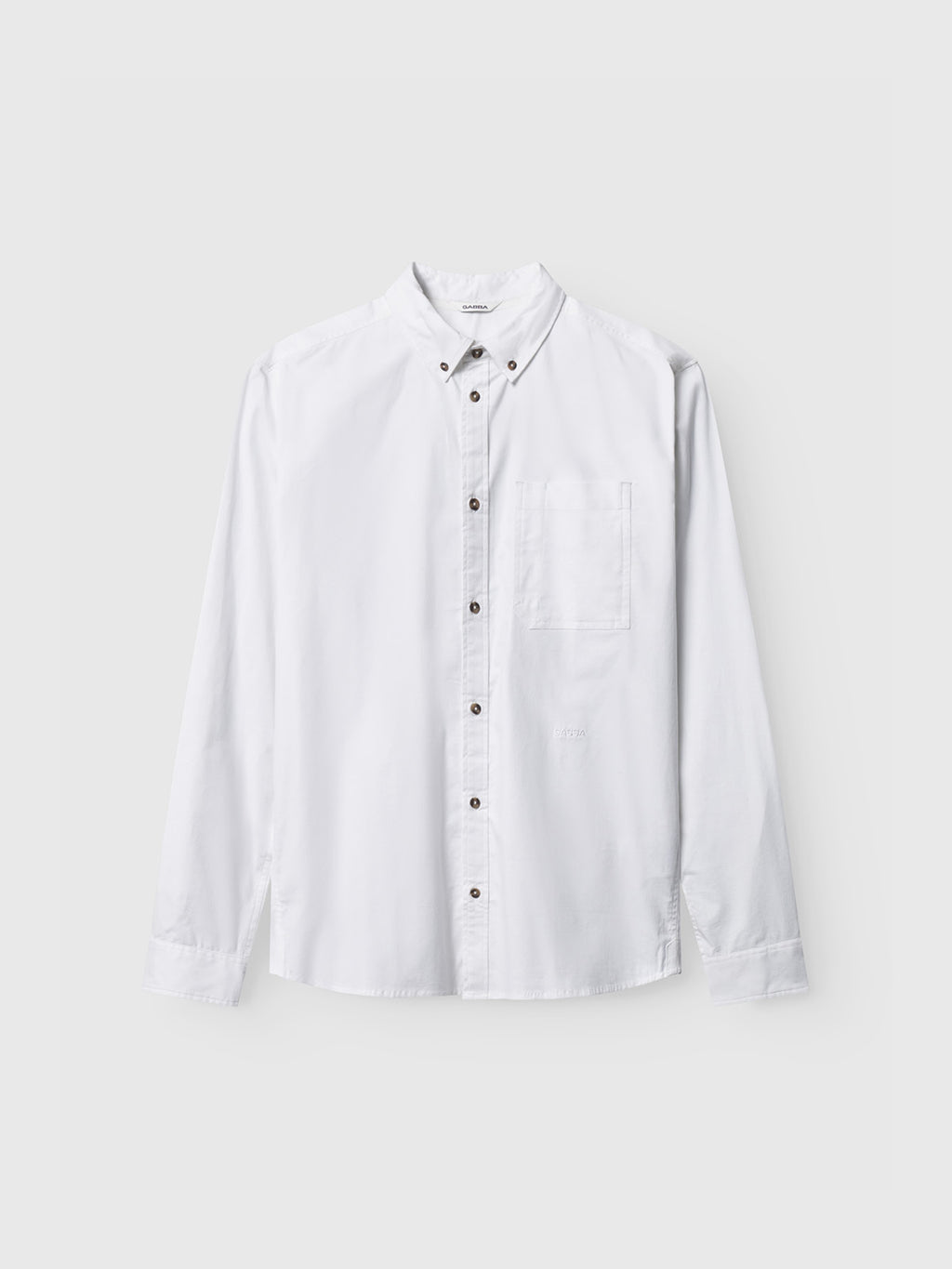 The Gabba Bent Reg Ox LS in white is a long-sleeve cotton shirt with a collar and chest pocket, featuring a timeless design, displayed flat on a light gray background.